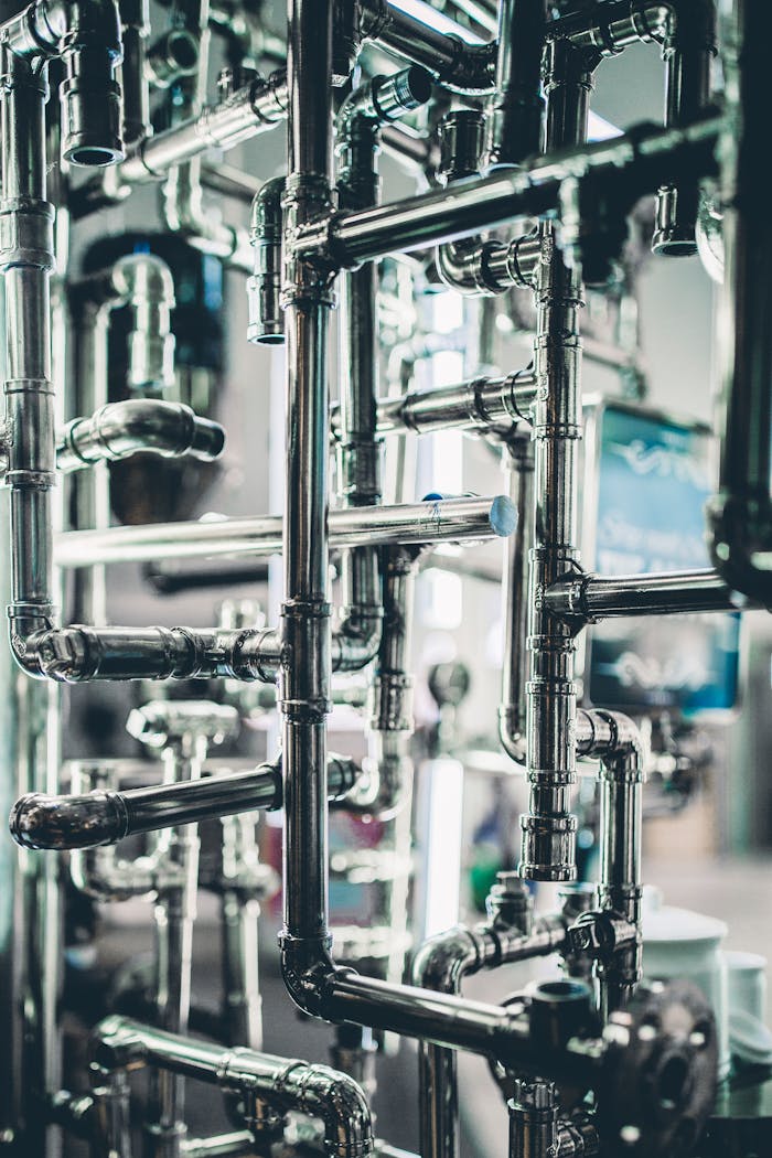 Services-03 Close-up of complex stainless steel pipes in an industrial setting, showcasing modern engineering.